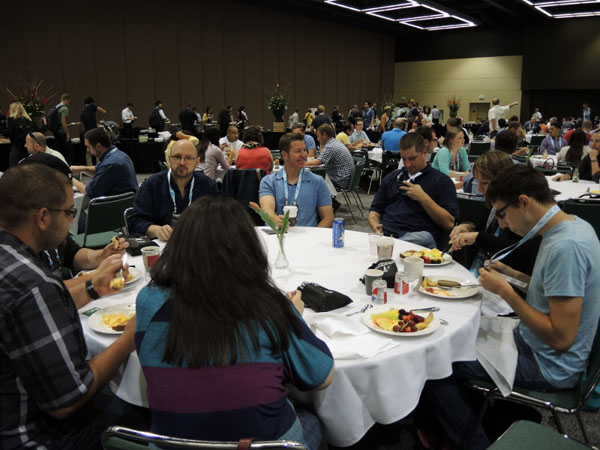 A round table with conference attendees eating lunch and networking.