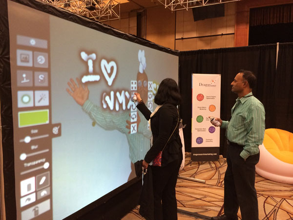 Conference attendees having fun drawing on the Graffiti board at the DragonSearch booth.