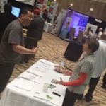 A man and women engaging at a conference booth
