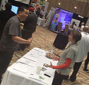 A man and women engaging at a conference booth