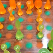 Chess pieces in orange and green on a polka dot board